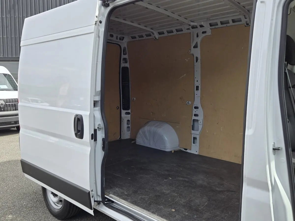Fiat Ducato Fourgon blanc vu de côté gauche, porte coulissante ouverte montrant l’espace de chargement vide.