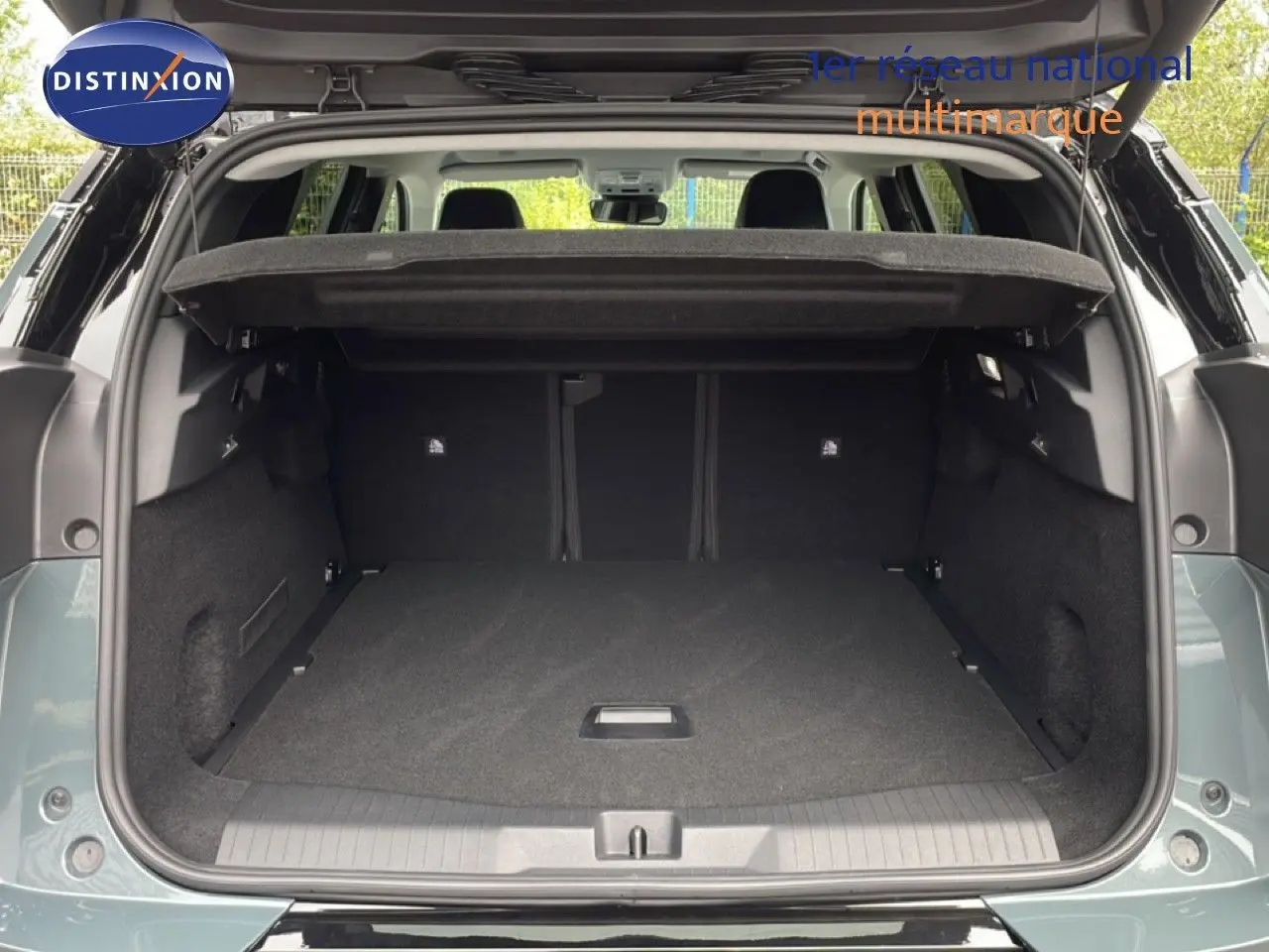 Coffre ouvert vu de l'arrière d'un Citroën C5 Aircross 2026 vert Astoria Metal, espace de chargement spacieux et propre.