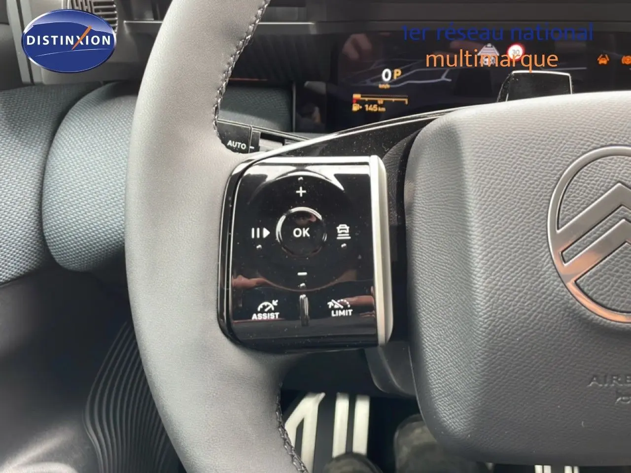 Gros plan sur le volant gris noir du Citroën C5 Aircross 2026, avec commandes intégrées et logo central visible.