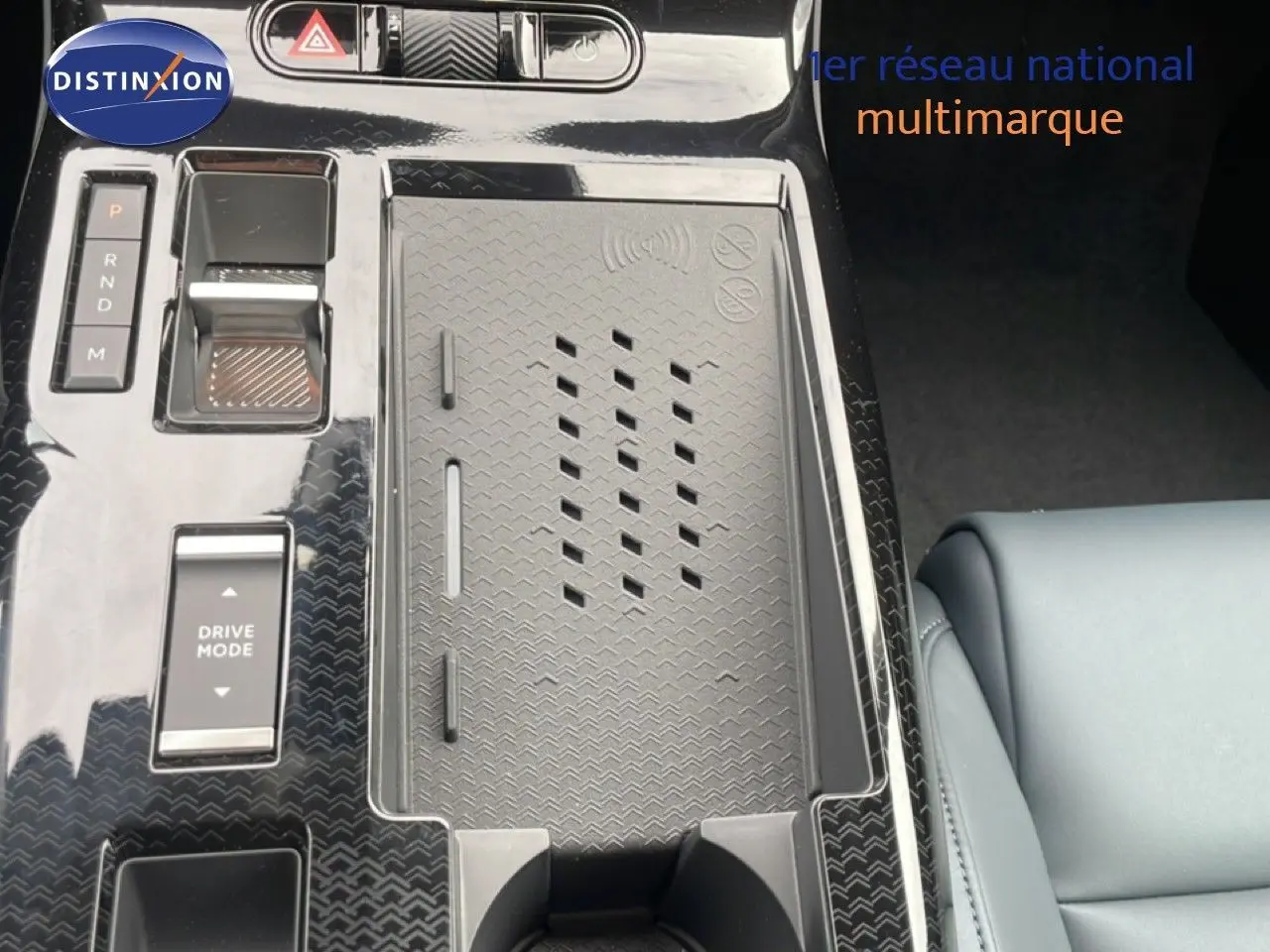 Vue rapprochée de la console centrale noire brillante du Citroën C5 Aircross 2026 avec commandes et porte-gobelets.