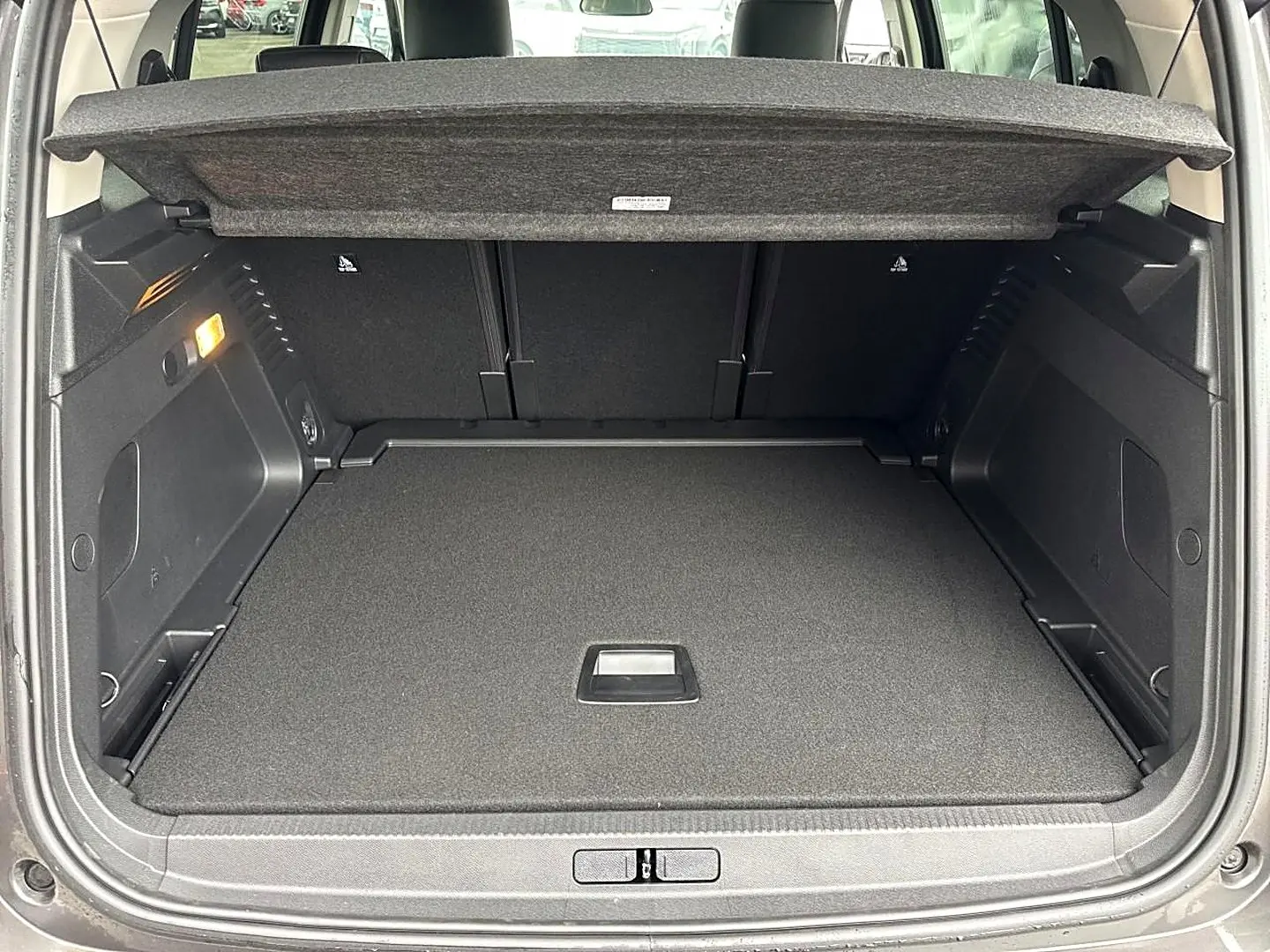 Coffre ouvert vu de l'arrière d'un Citroën C5 Aircross gris platinium, montrant l'espace de chargement et la tablette cache-bagages.