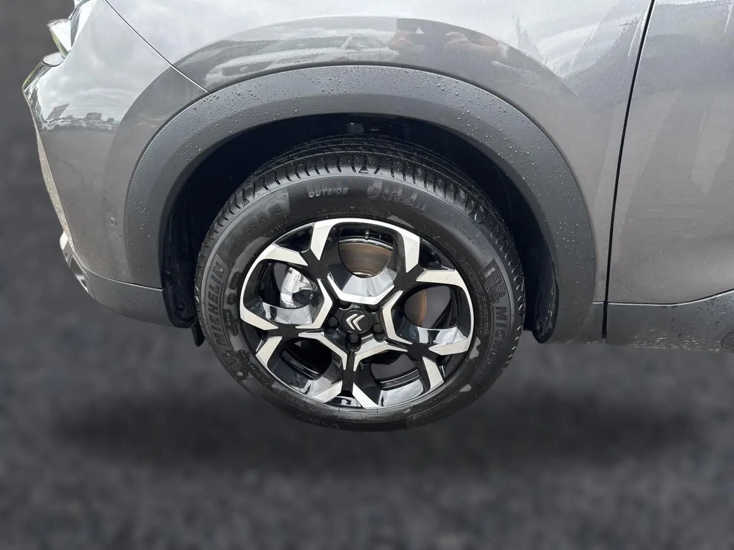 Gros plan sur la roue avant gauche du Citroën C5 Aircross gris platinium avec jante alu bicolore et pneus Michelin.