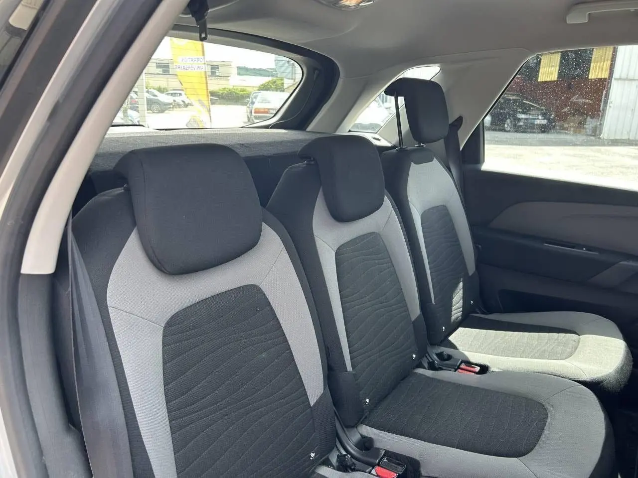 Vue intérieure sur les sièges arrière en tissu gris et noir de la Citroën C4 Picasso PureTech 110 Confort 2016.