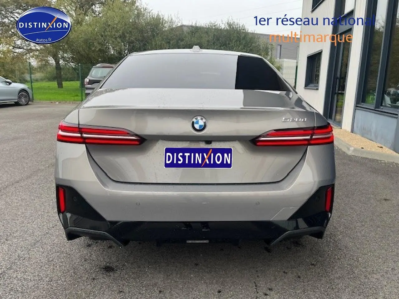 Vue arrière d'une BMW Série 5 gris métallisé (520da M Sport) avec feux LED et diffuseur noir brillant.