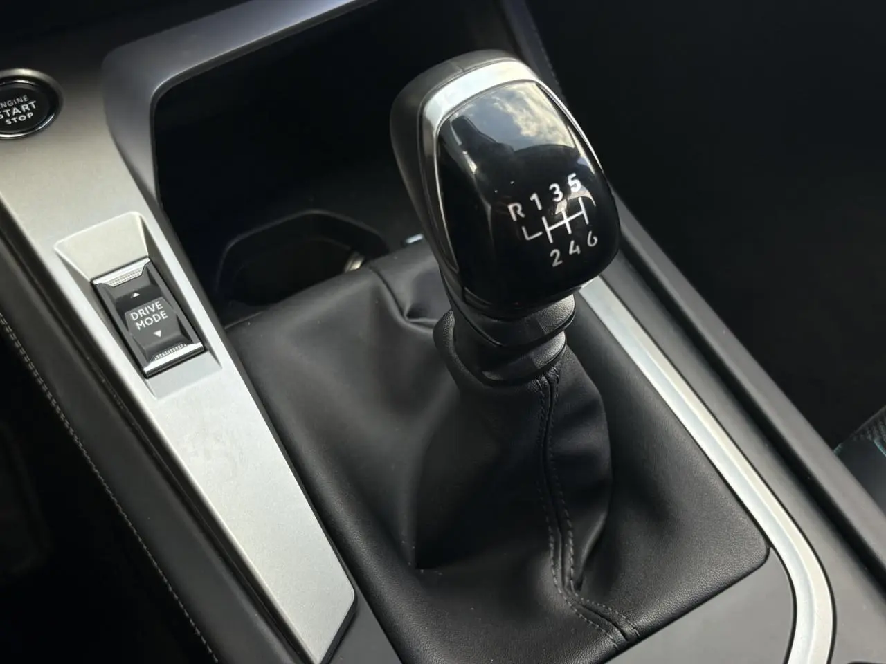Gros plan sur le levier de vitesses manuel noir et la commande Drive Mode dans l’habitacle d’une Peugeot 308 2024.