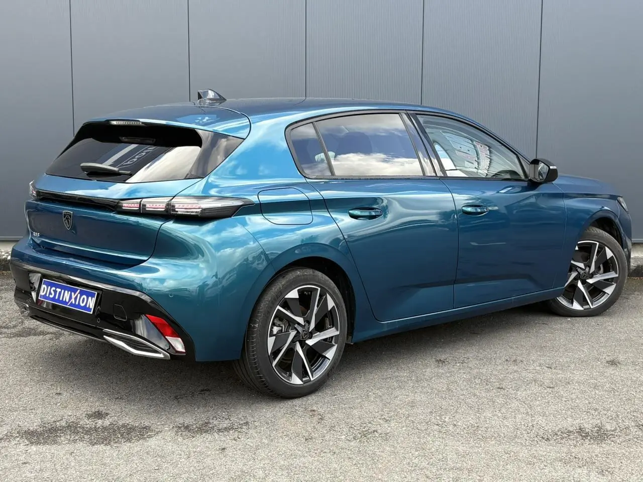 Peugeot 308 Bleu Obsession vue 3/4 arrière droit, avec jantes alliage et vitres surteintées.