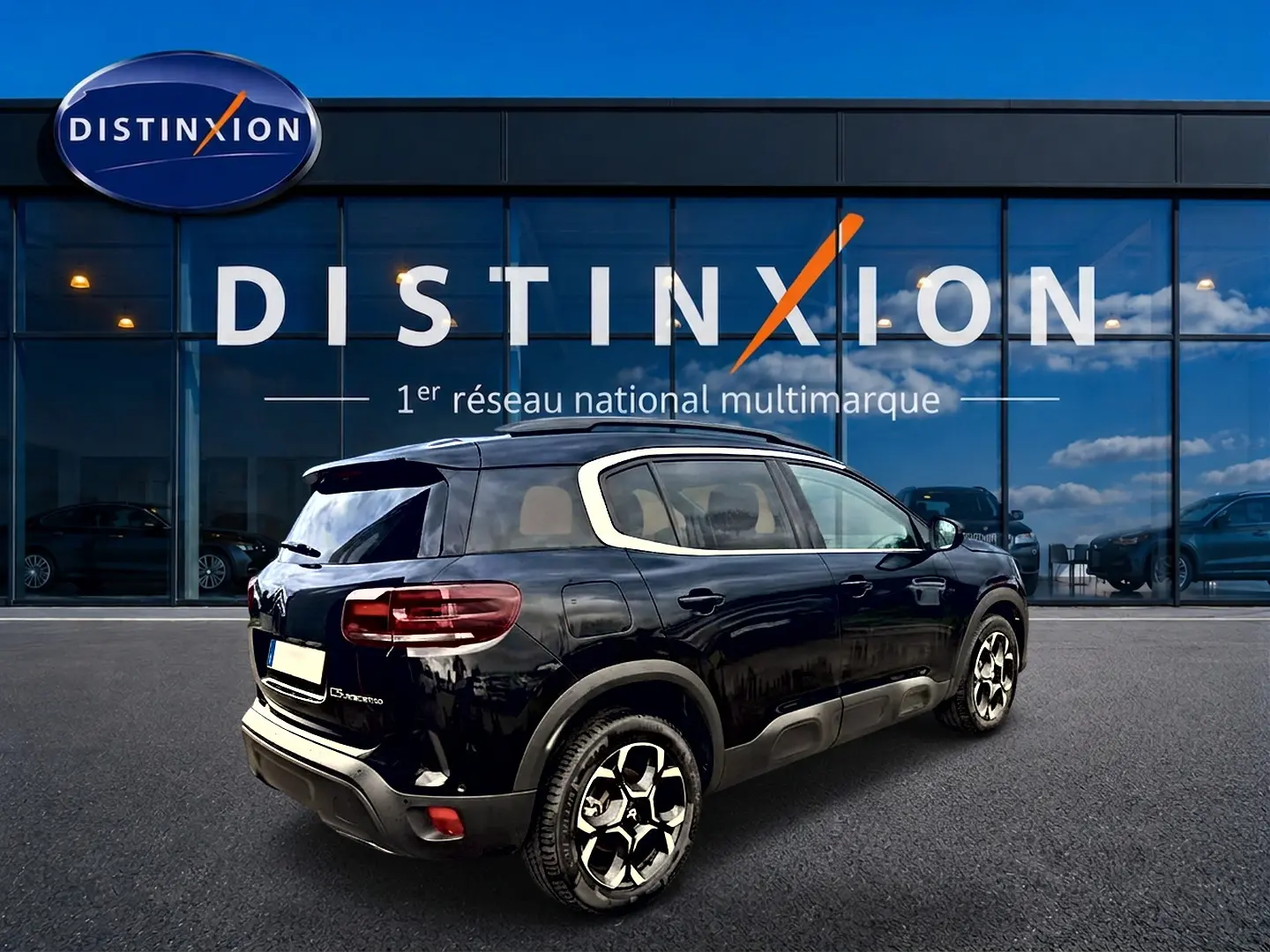 Citroën C5 Aircross noir vue 3/4 arrière droit, avec barres de toit et jantes alliage distinctives.