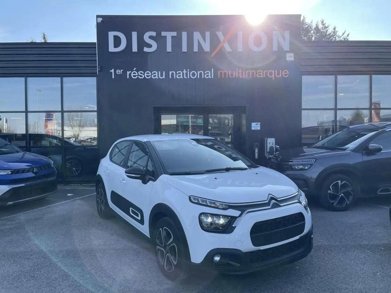 Citroën C3 blanc banquise vue 3/4 avant droit avec protections latérales noires et jantes 3D 16 pouces.