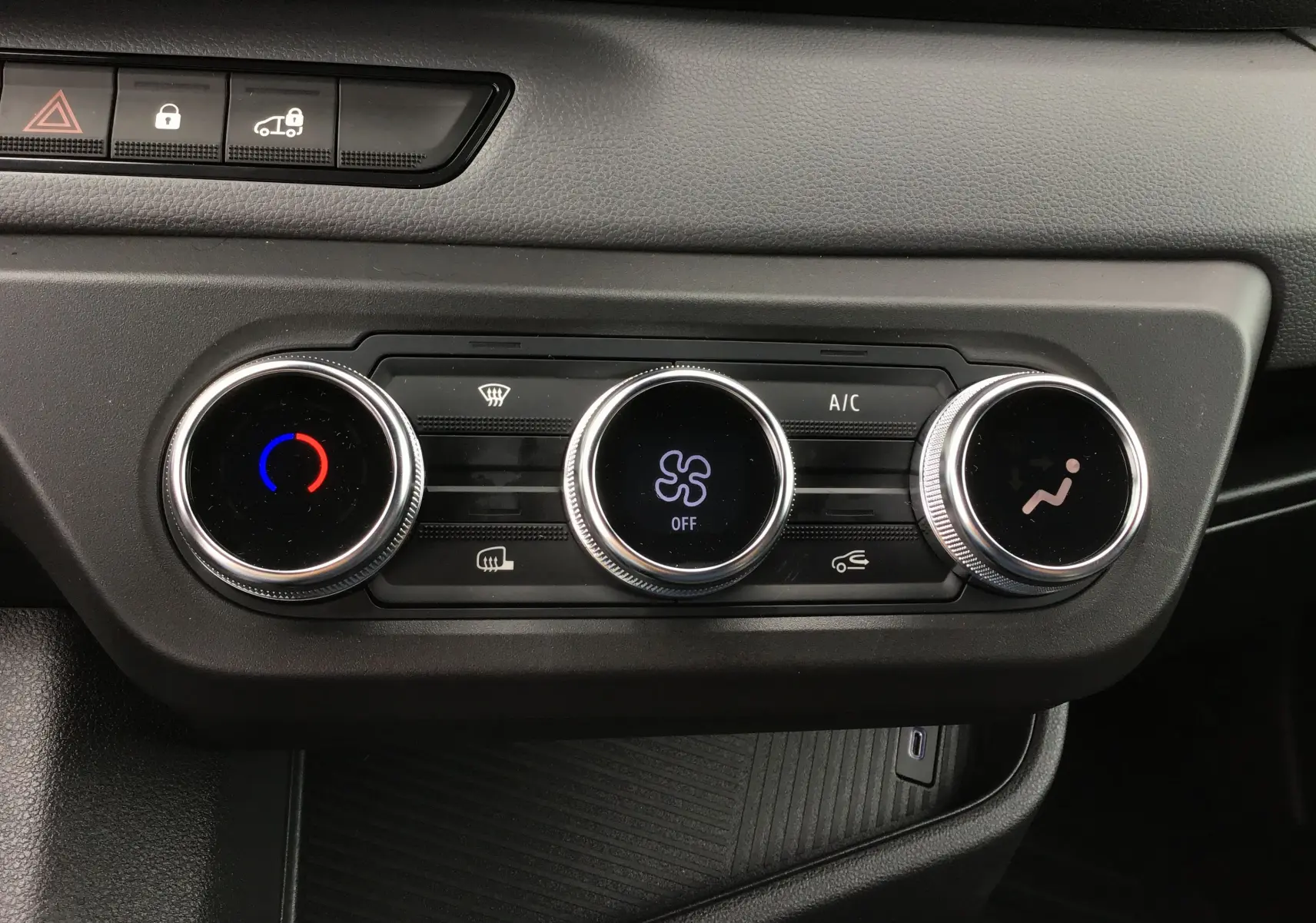 Vue rapprochée des commandes de climatisation du tableau de bord du Renault Master blanc 2025, avec réglages circulaires et affichage digital.