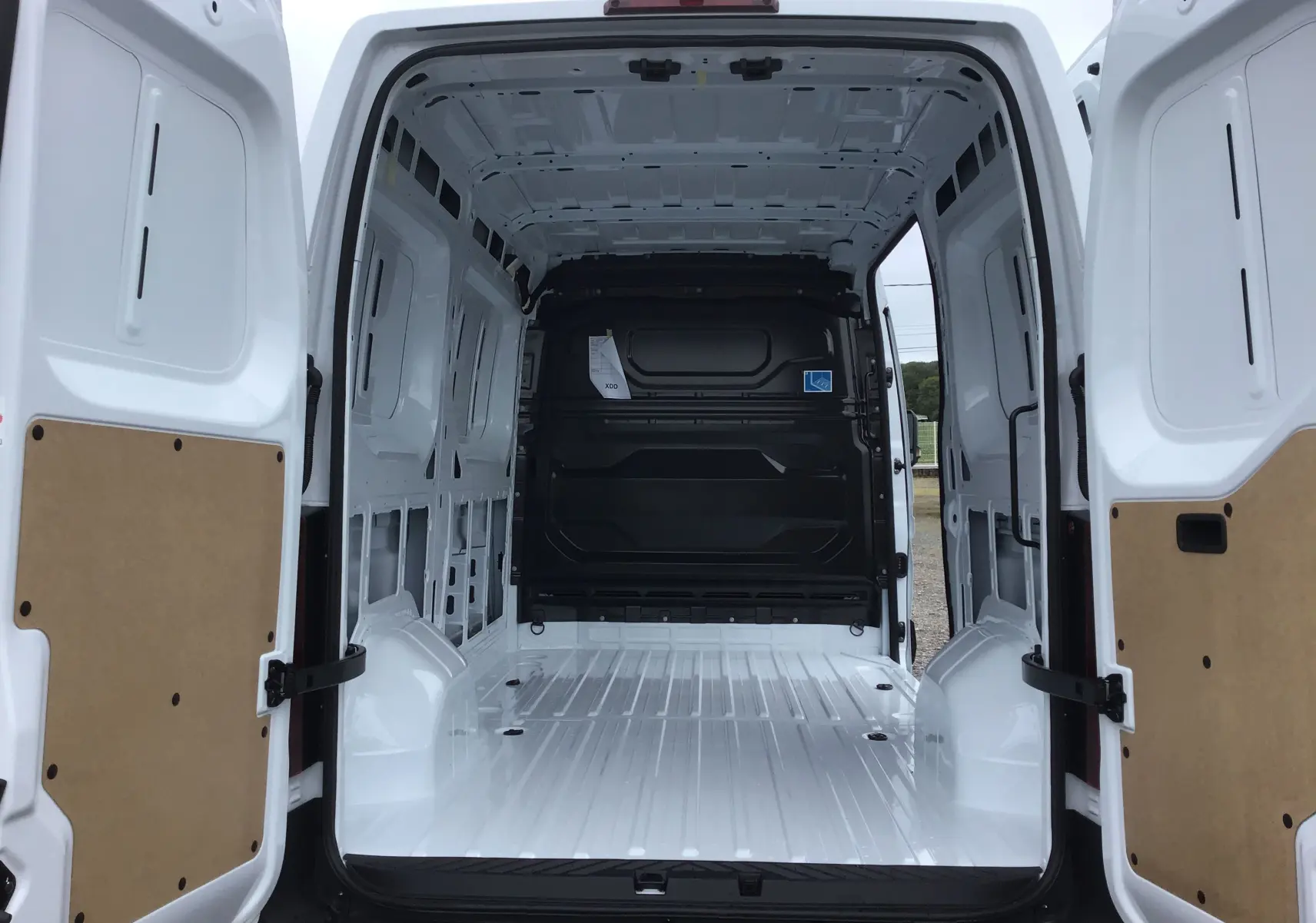 Vue arrière intérieure du Renault Master blanc L2H2 2025, montrant l’espace de chargement vide et les portes ouvertes.