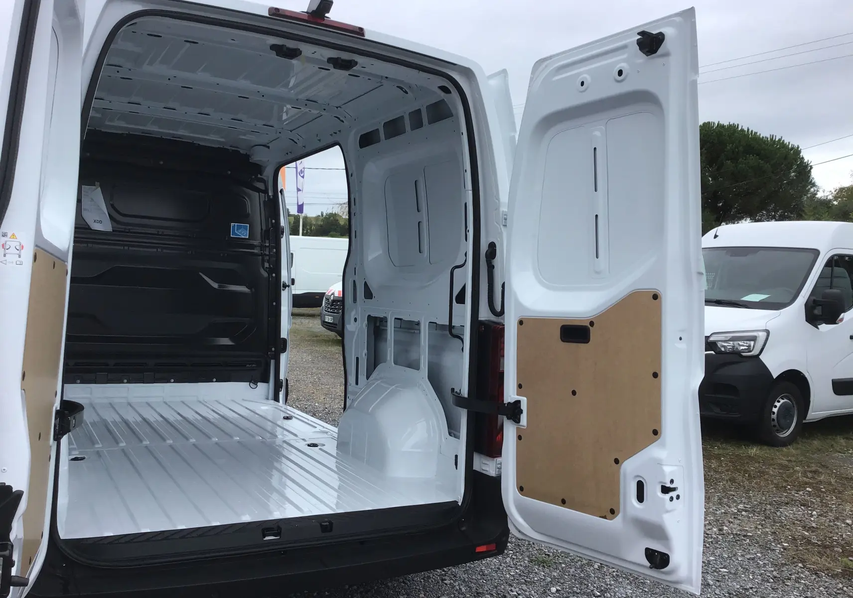 Vue arrière du Renault Master blanc 2025 avec portes ouvertes dévoilant la grande zone de chargement vide et protégée.