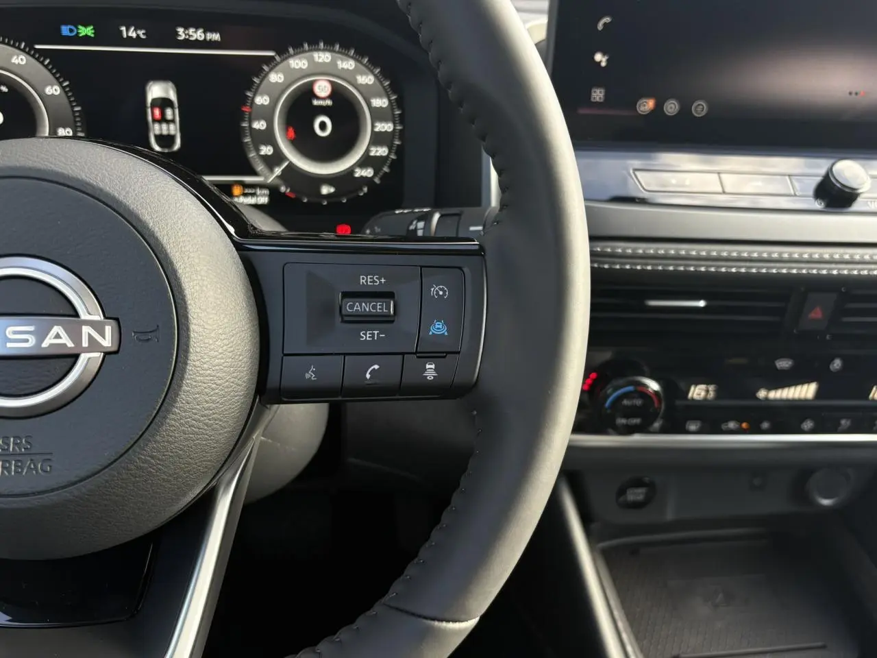 Vue rapprochée du volant noir du Nissan Qashqai 2025 avec commandes au volant et tableau de bord numérique.