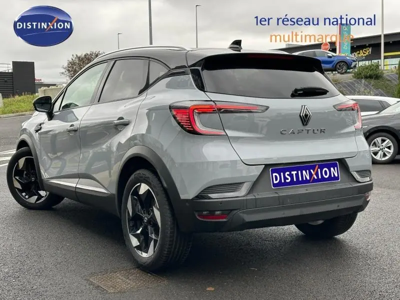 Renault Captur 2025 gris Rafale/noir étoilé en 3/4 arrière droit, avec jantes alu noires et toit noir contrasté.