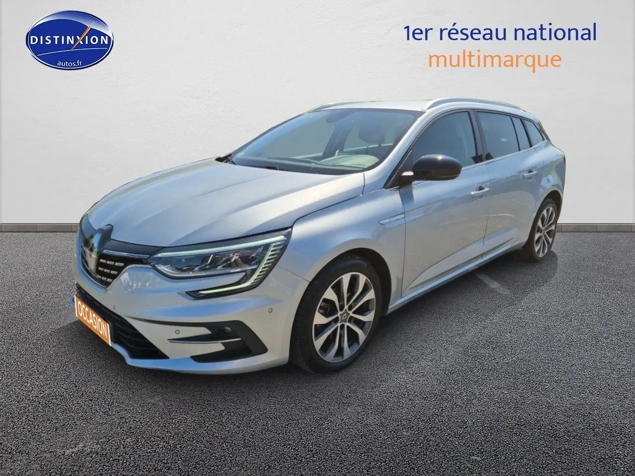 Renault Mégane Break gris titanium vue 3/4 avant droit avec jantes alliage et feux LED allumés.