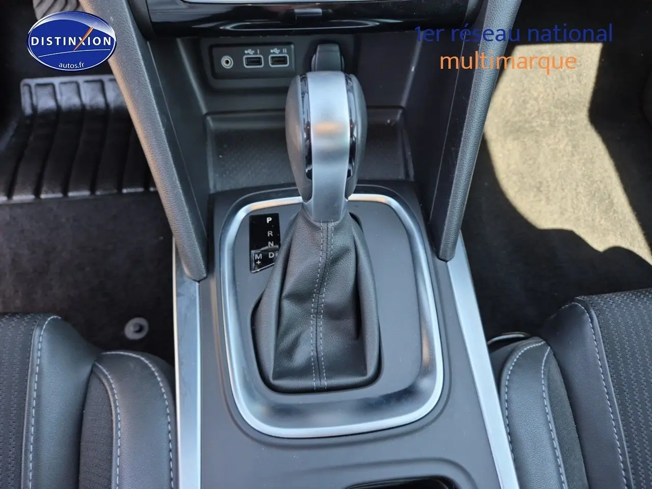 Le levier de vitesse automatique noir de la Renault Mégane Break 2024 vu de dessus, entouré de garnitures grises.