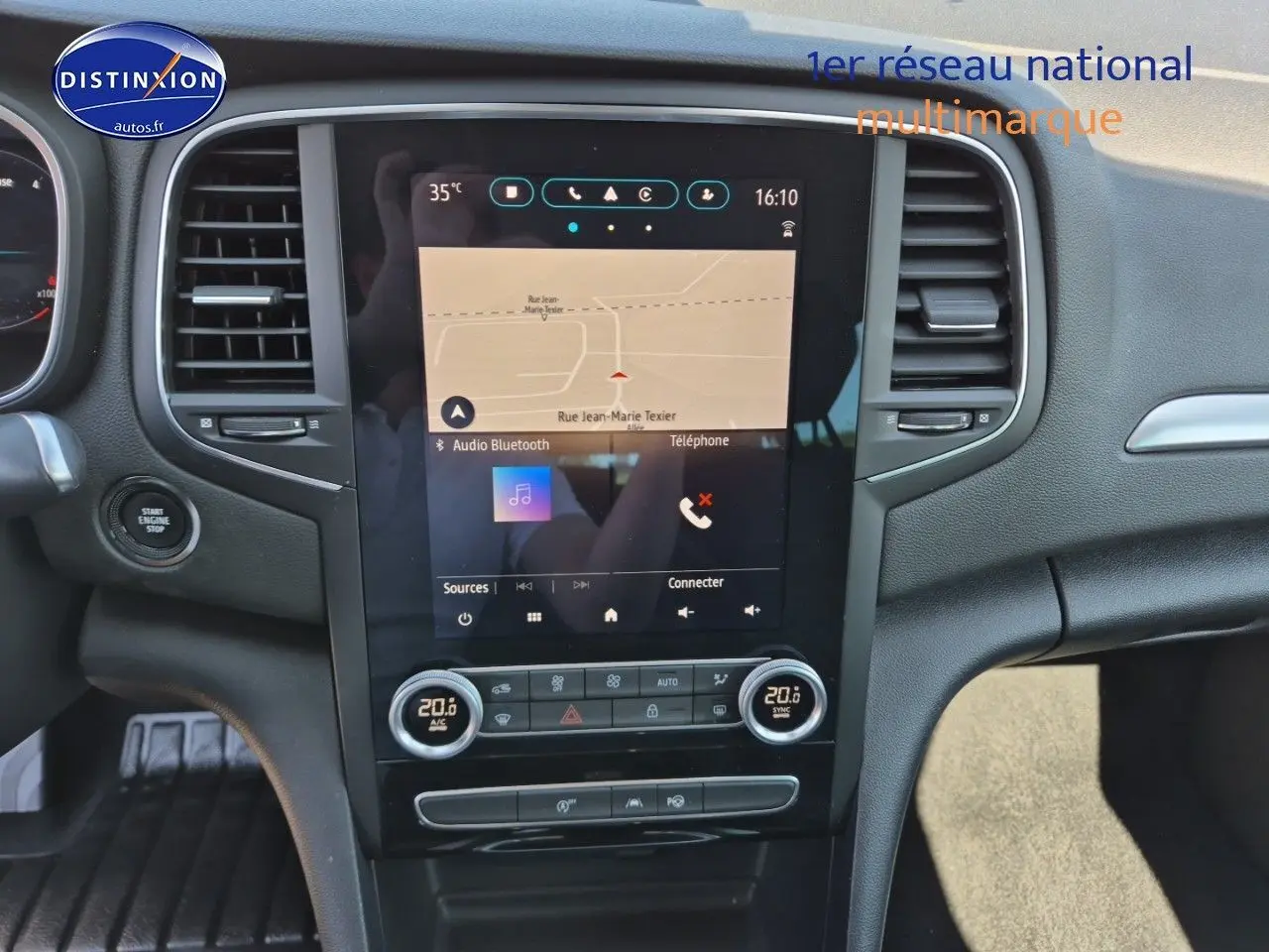 Vue intérieure centrée sur l'écran tactile et la console centrale d'une Renault Mégane Break gris titanium 2024.