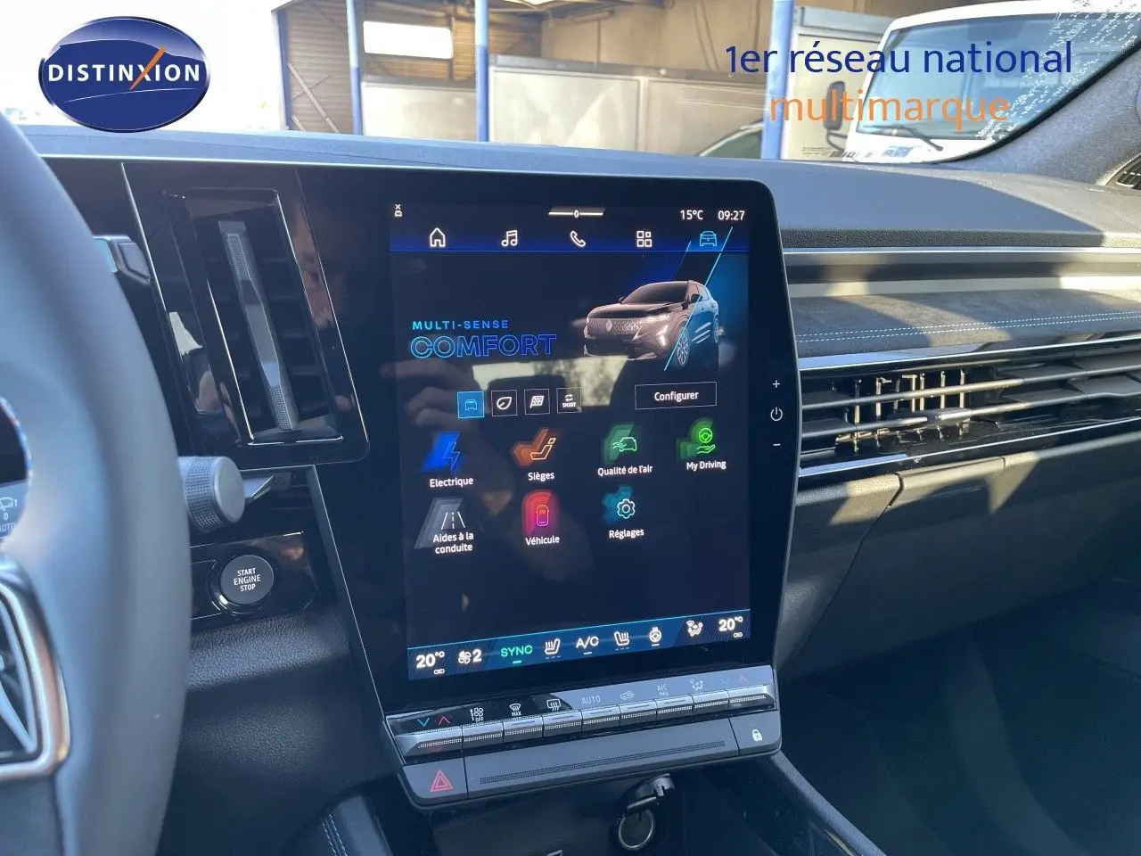 Vue intérieure centrée sur l'écran tactile vertical du tableau de bord du Renault Austral noir étoile métal, avec commandes clim et start/stop visibles.
