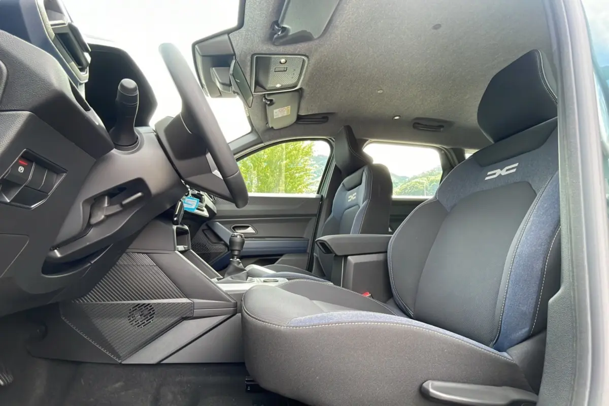 Intérieur du Dacia Bigster TCE 130 4x4 Expression Plus 2025, vue côté conducteur sur sièges tissu noir et bleu avec logo DC.