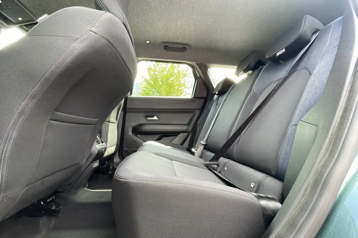 Vue intérieure arrière du Dacia Bigster 2025 vert cèdre, montrant les sièges arrière en tissu noir avec ceinture de sécurité.