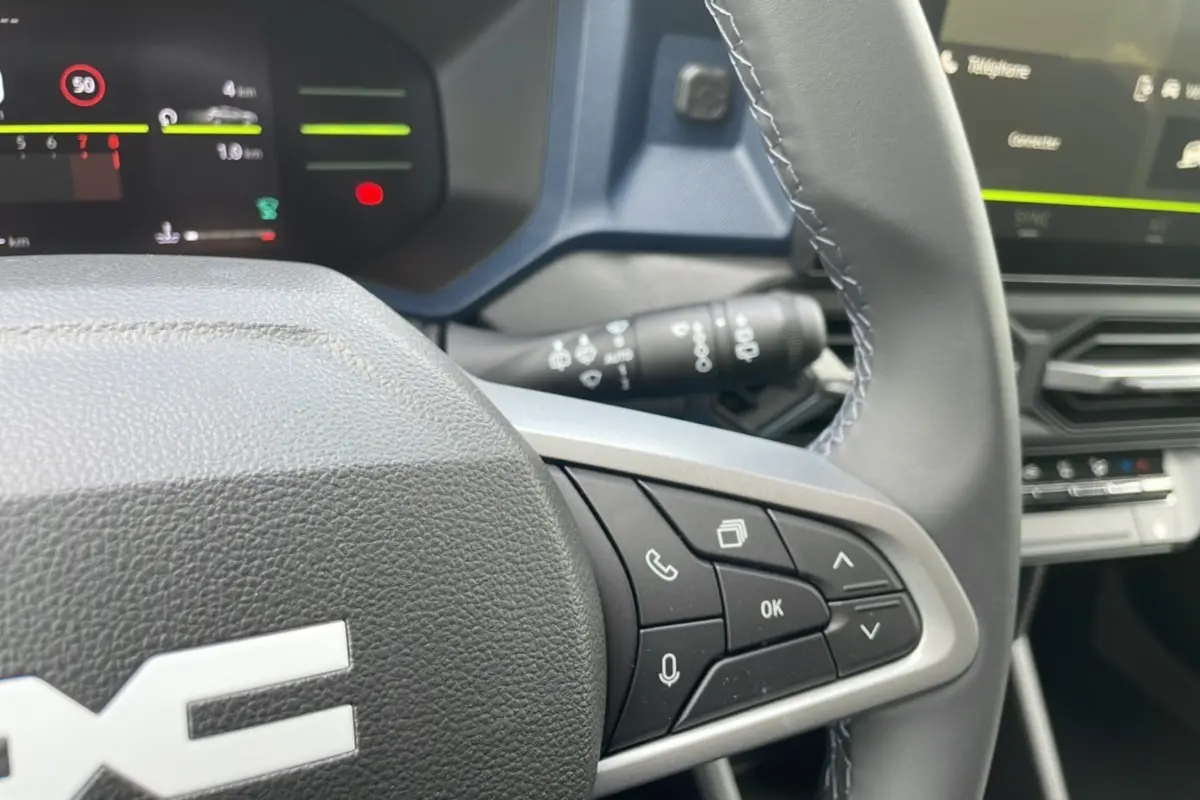 Gros plan sur le volant multifonction du Dacia Bigster 2025 avec commandes vocales et téléphone intégrées.