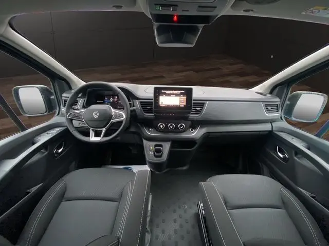 Vue intérieure avant du Renault Trafic Cabine Approfondie 2025 noir, tableau de bord moderne avec écran central tactile et volant multifonction.