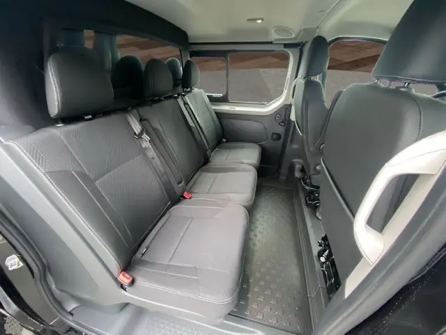 Vue intérieure côté droit montrant les trois sièges indépendants arrière en cuir noir du Renault Trafic Cabine Approfondie 2025.