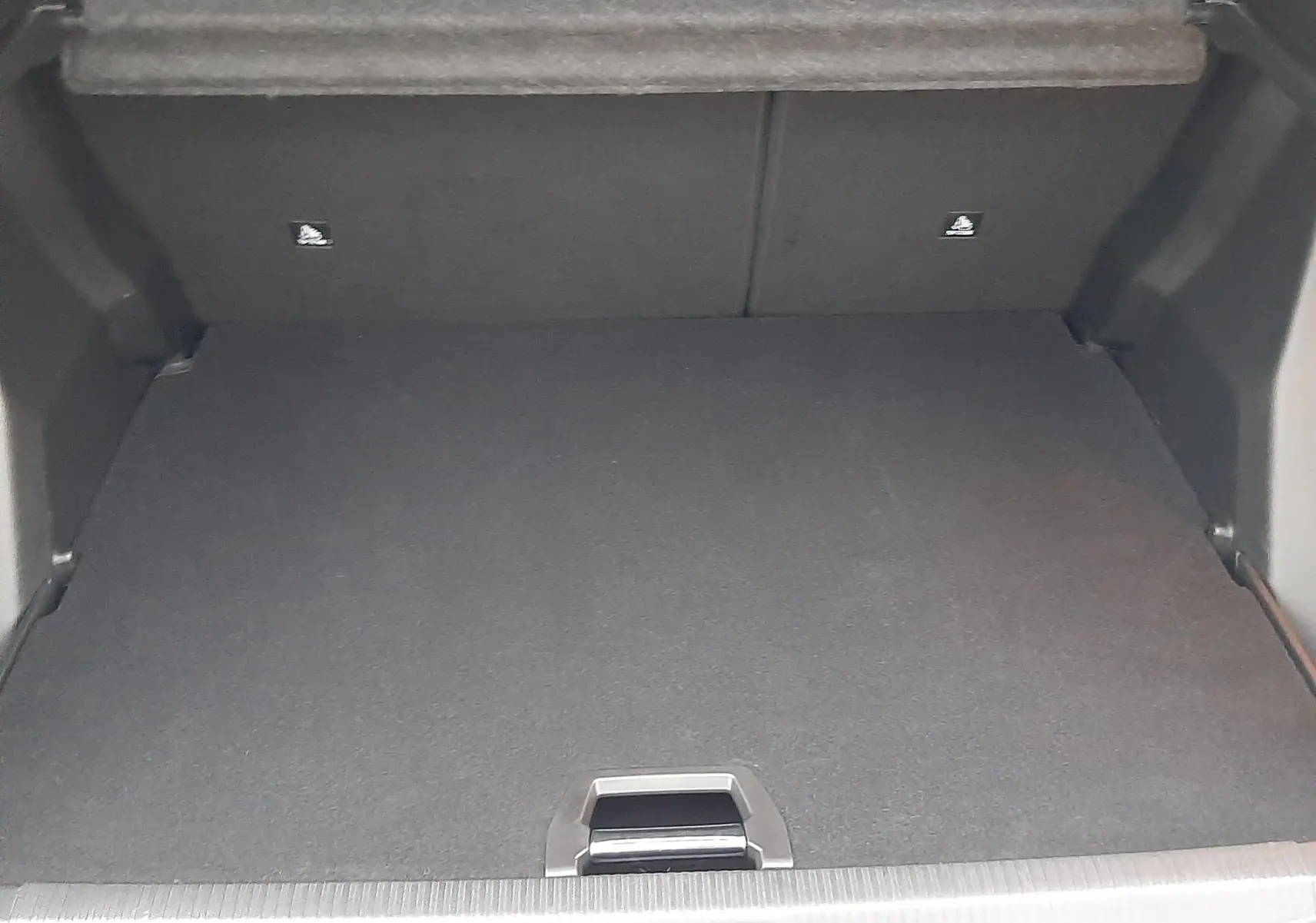 Coffre ouvert vu de l'arrière d'un Peugeot 2008 2023, intérieur noir et plancher plat sans chargement visible.