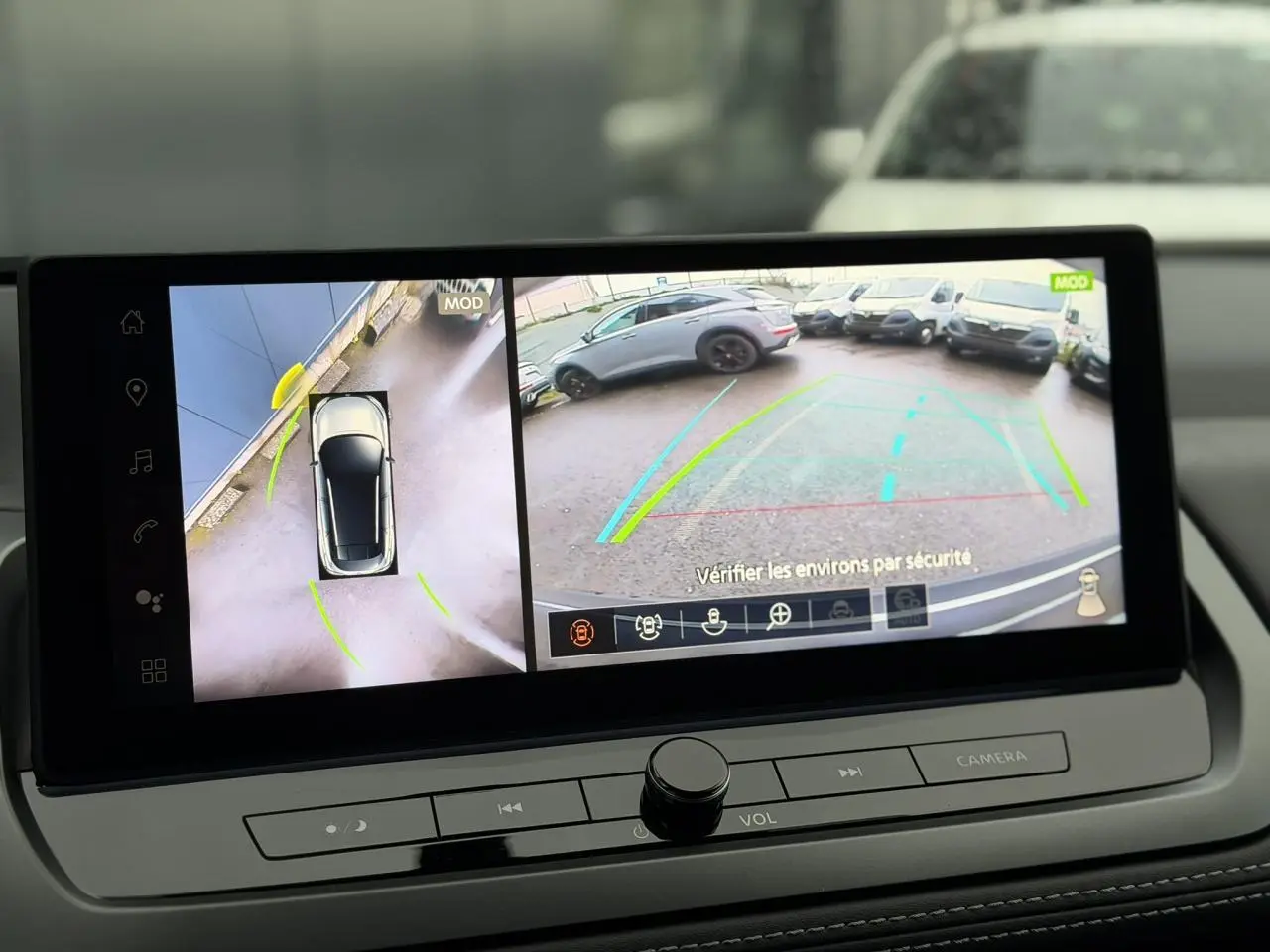 Écran intérieur affichant la caméra 360° et la vue arrière du Nissan Qashqai III gris Squale en stationnement.