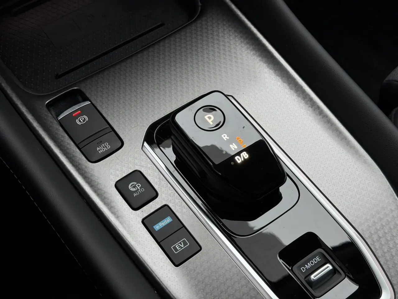 Gros plan sur la console centrale du Nissan Qashqai gris, montrant le sélecteur de boîte auto et les boutons de commande.