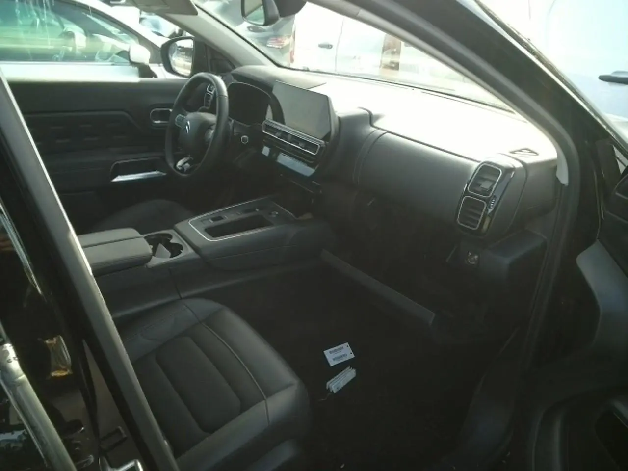 Intérieur noir du Citroën C5 Aircross 2024 vu côté conducteur, avec tableau de bord moderne et écran tactile central.