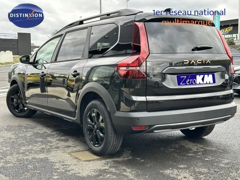 Vue 3/4 arrière droite du Dacia Jogger noir nacré métallisé avec barres de toit et jantes alu noires.