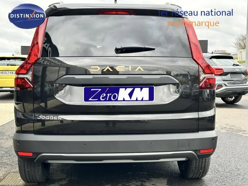 Vue arrière d'un Dacia Jogger noir nacré métallisé avec feux arrière en forme de L et logo doré sur le hayon.