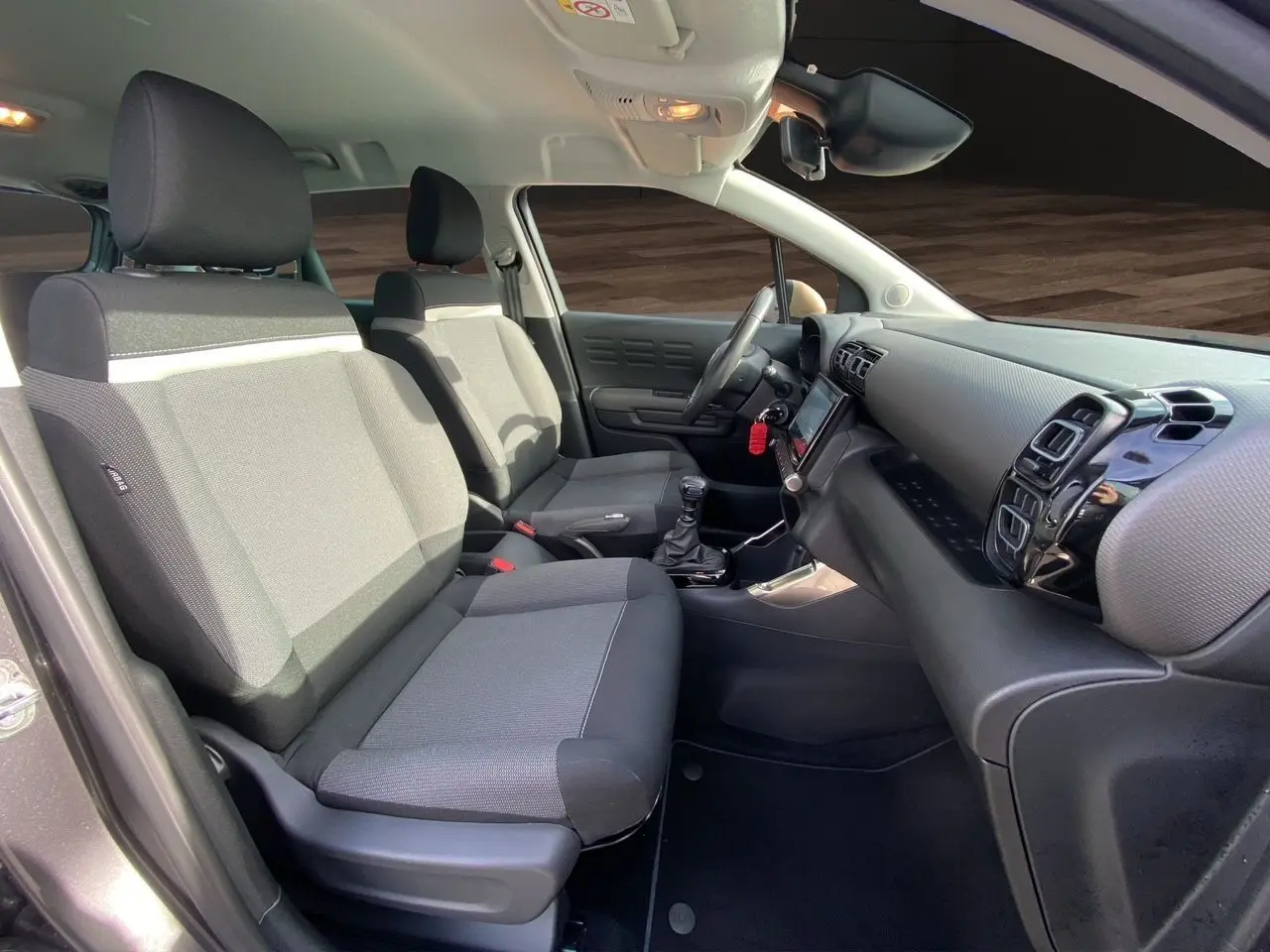 Vue intérieure côté droit de la Citroën C3 Aircross 2022, sièges tissu gris noir et tableau de bord moderne.