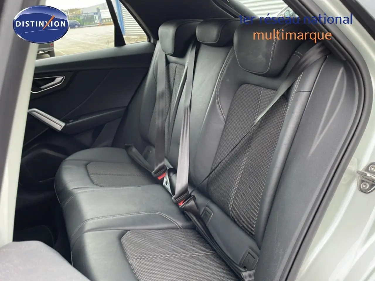 Vue intérieure sur la banquette arrière en cuir noir de l'Audi Q2 35 2.0 TDI S-Line, porte arrière ouverte.
