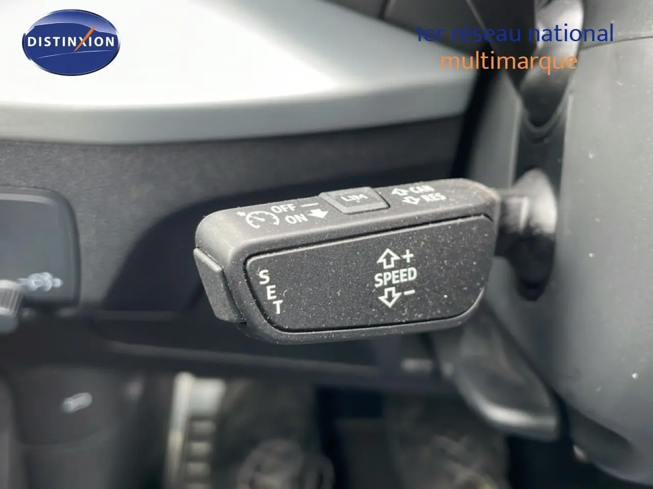 Gros plan sur la commande de régulateur de vitesse dans l’Audi Q2 35 2.0 TDI 150CH S-TRONIC7 S-LINE argent rose métal.