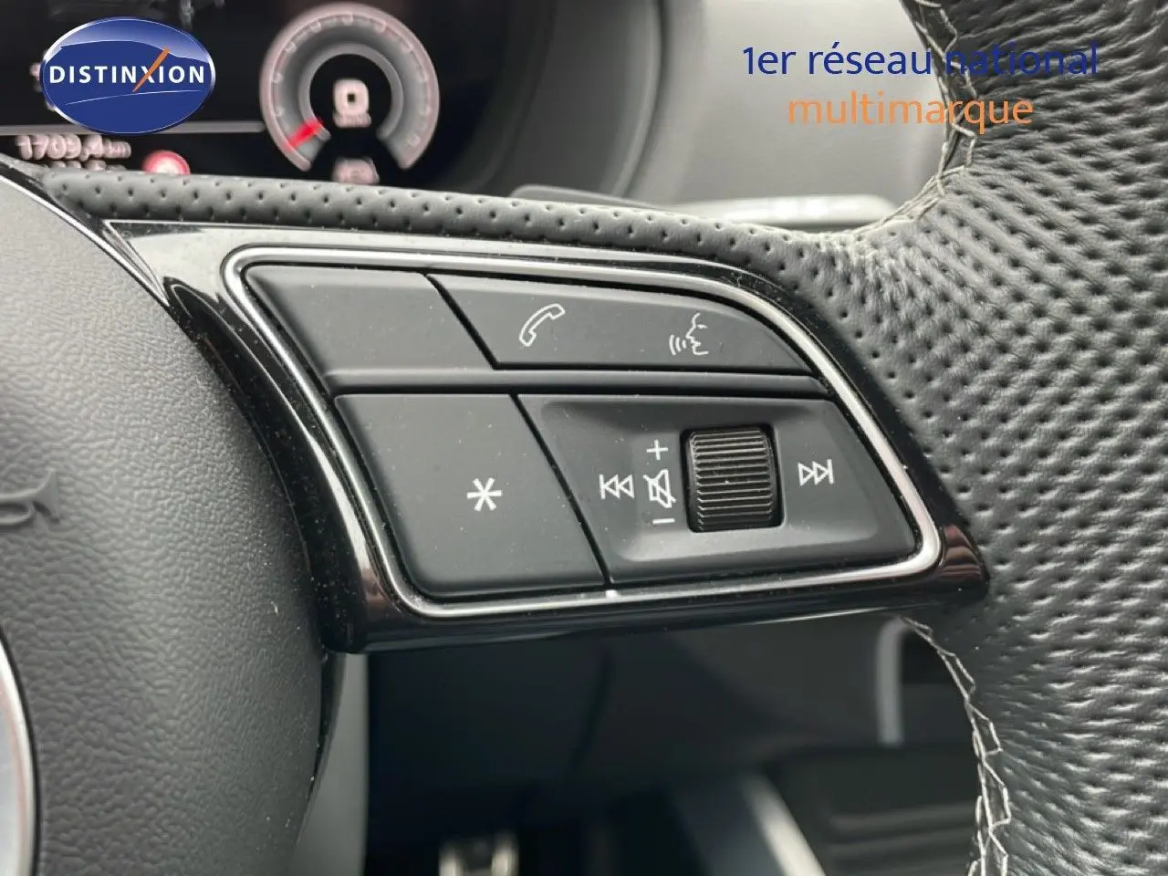 Gros plan sur les commandes multifonctions noires du volant perforé de l'Audi Q2 35 2.0 TDI S-Line 2025.
