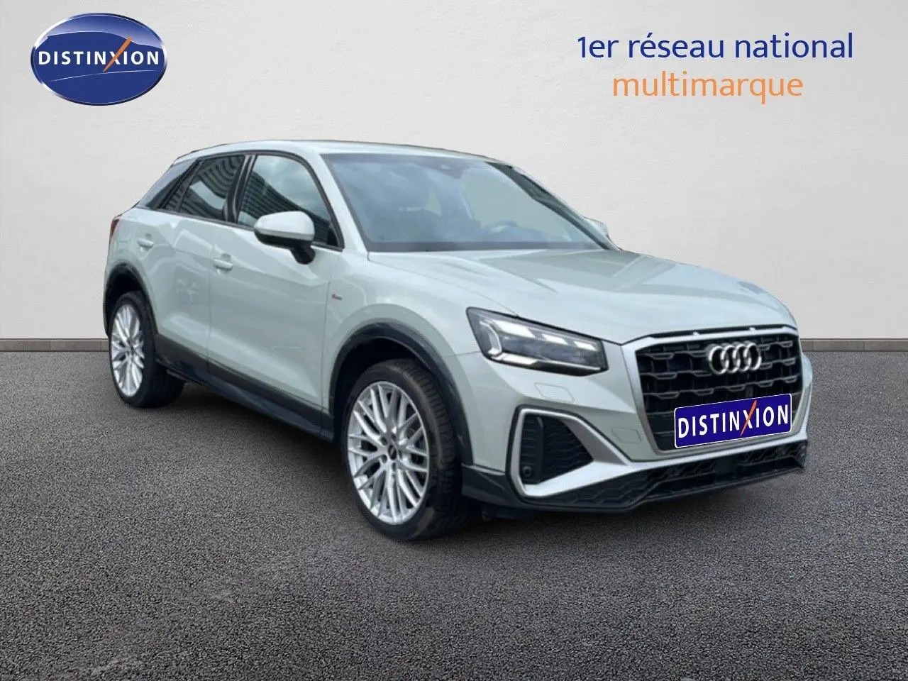 Audi Q2 argent rose métal vue 3/4 avant droit, avec calandre noire et jantes alliage multibranches.