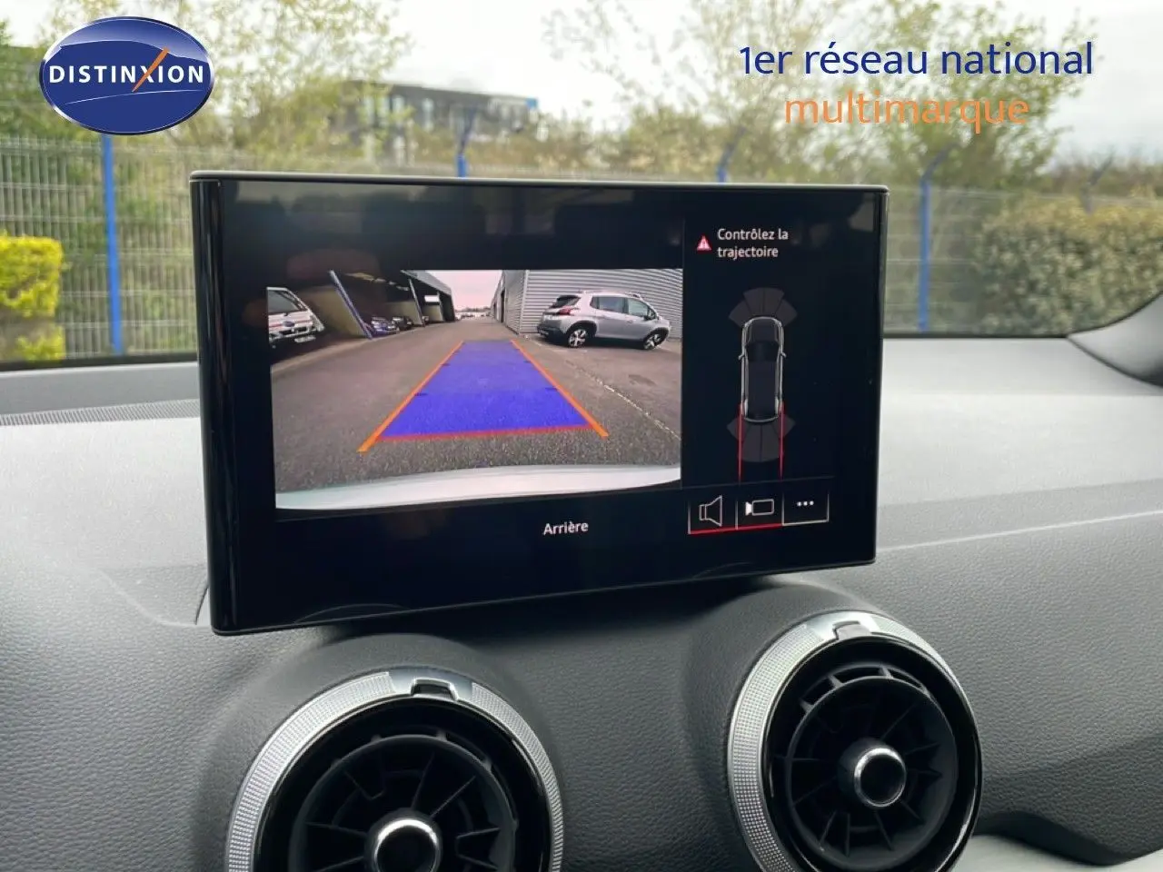 Écran central de l’Audi Q2 35 2.0 TDI S-Line 2025 montrant la caméra de recul avec vue arrière et guidage coloré.