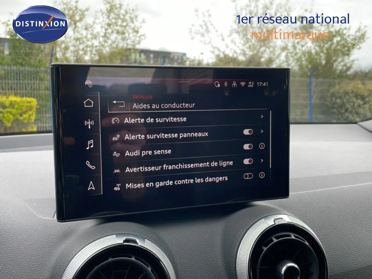 Écran central tactile affichant les aides à la conduite dans l’Audi Q2 argent rose, vue intérieure avant.