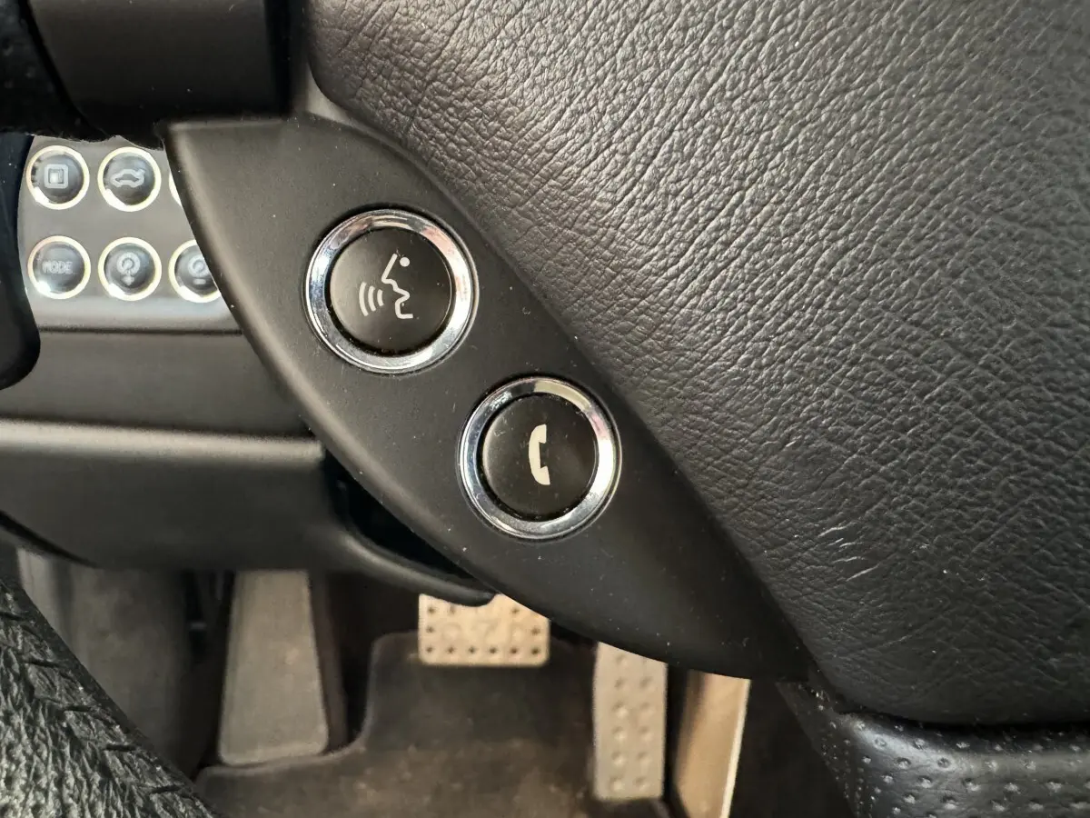 Gros plan sur les boutons de commande vocale et téléphone sur le volant en cuir noir de la Maserati Granturismo S 4.7.