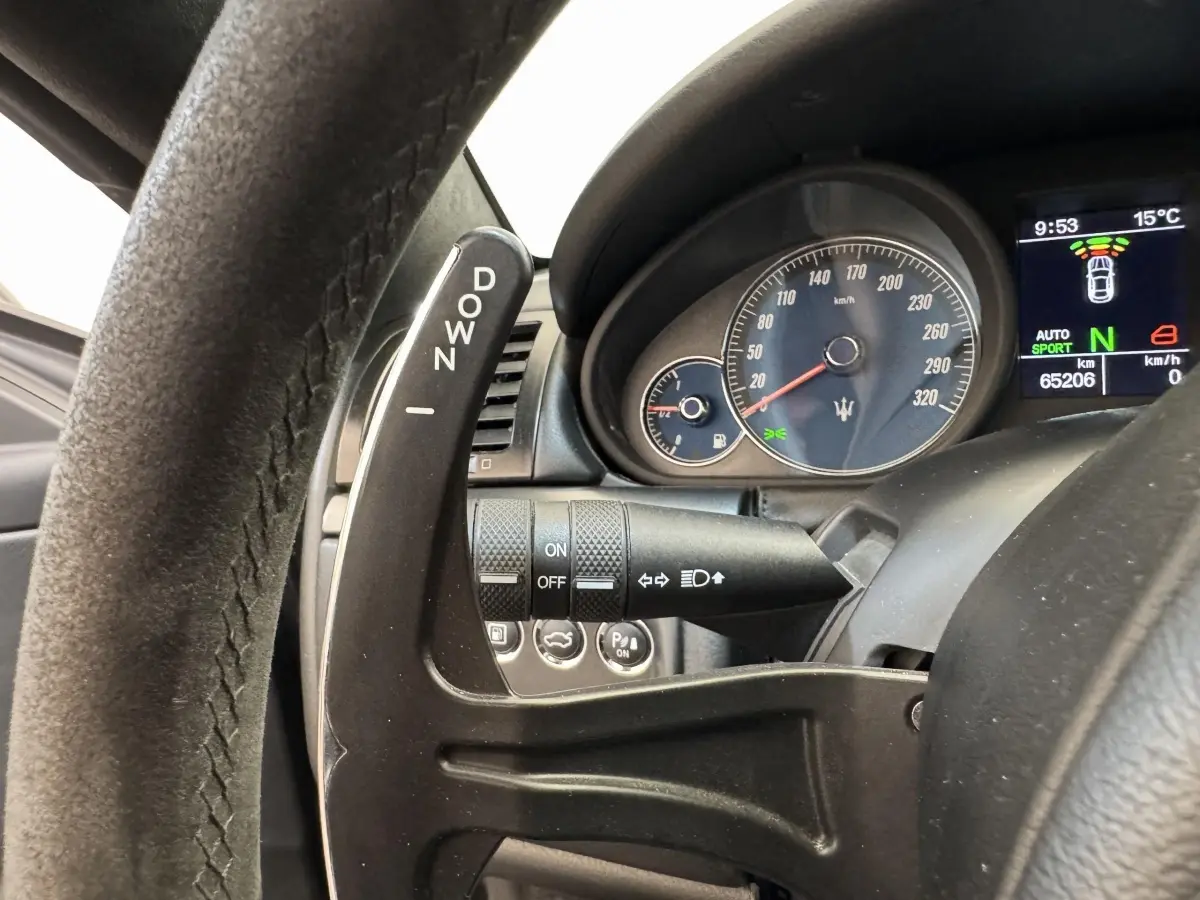 Gros plan sur le levier de changement de vitesse au volant et le compteur gris foncé d'une Maserati Granturismo S 4.7 2010.