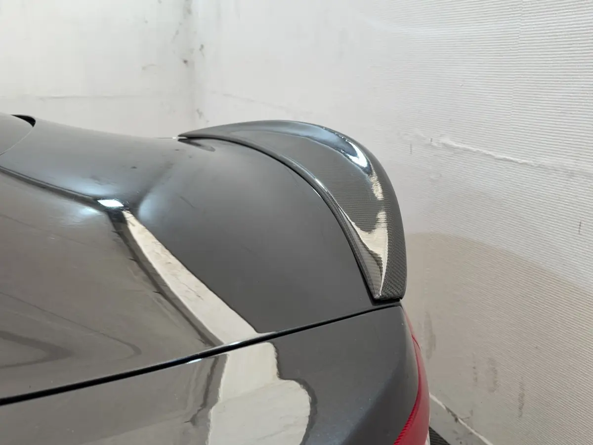 Détail du spoiler arrière en carbone sur une Maserati Granturismo S 4.7 gris foncé vue de trois quarts arrière droit.