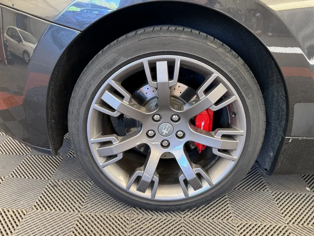 Gros plan sur la roue avant droite gris foncé d'une Maserati Granturismo S 4.7 avec étrier de frein rouge visible.