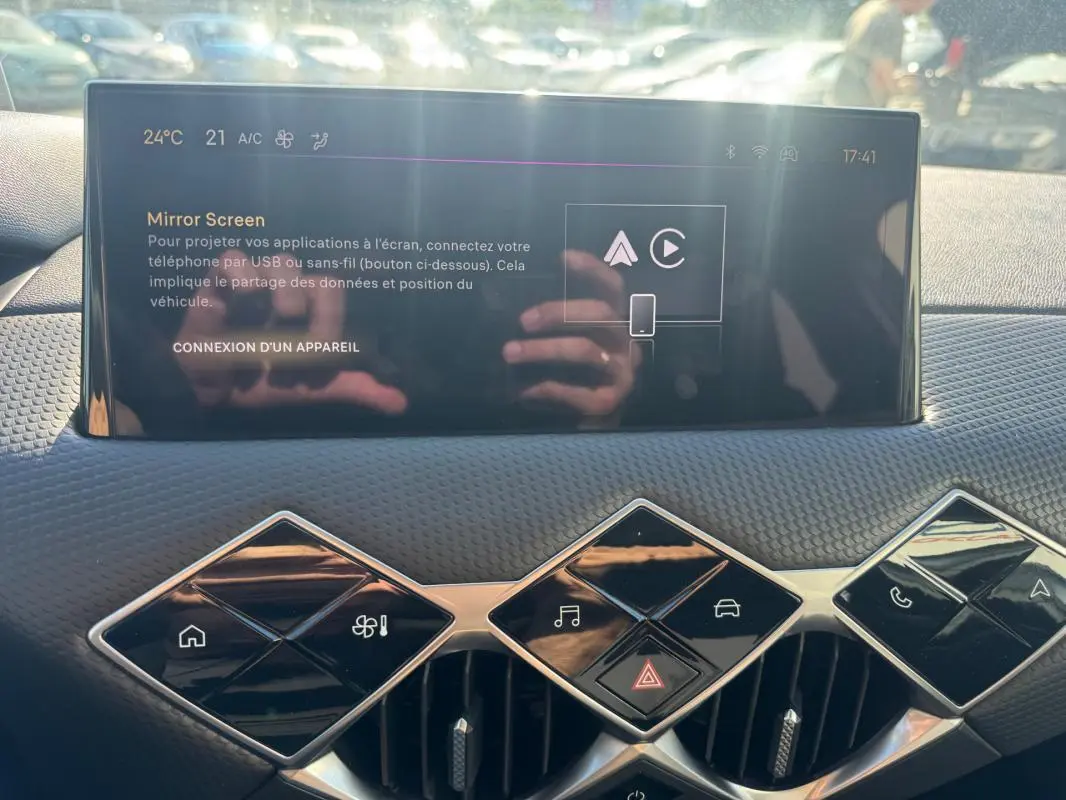 Vue rapprochée de la console centrale du DS3 2024, écran tactile avec commandes en losange et finition noire texturée.