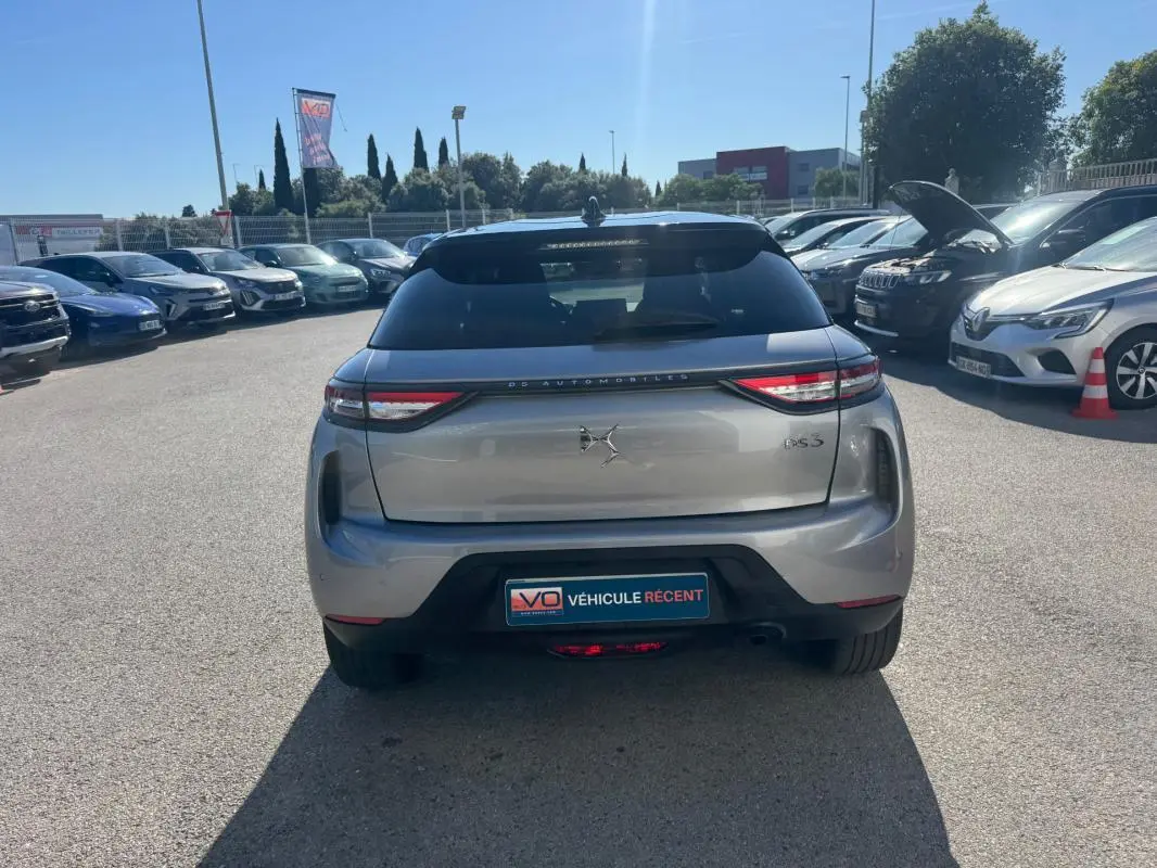 Vue arrière d'une DS3 gris métallisé 2024 avec feux LED fins et jantes alliage 18 pouces, stationnée en extérieur.