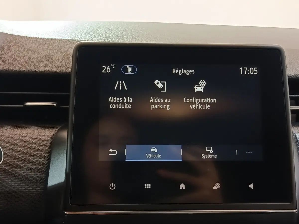 Écran tactile central de la Renault Clio Business E-TECH 140 blanc, affichant les réglages d’aides à la conduite.