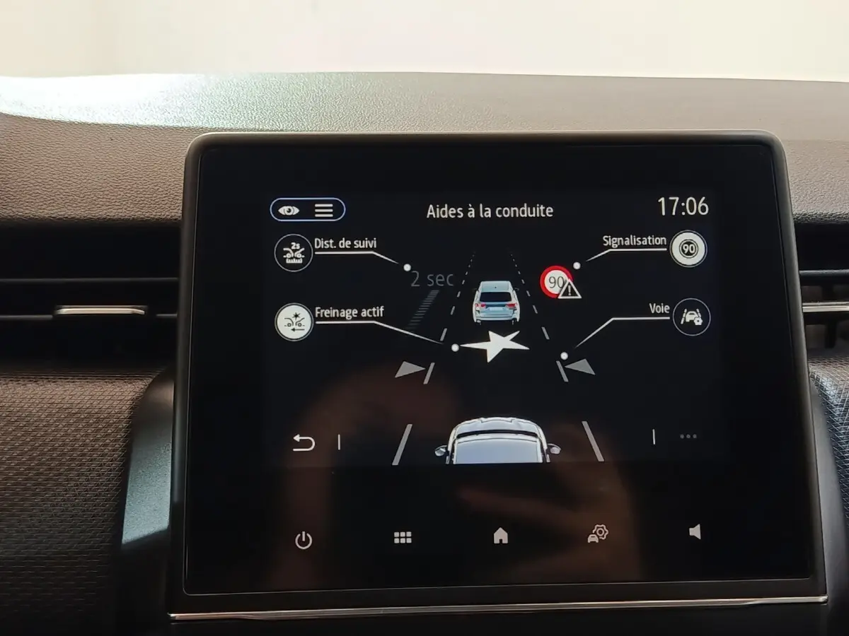 Écran tactile central de la Renault Clio Business E-TECH 140 blanc montrant les aides à la conduite.
