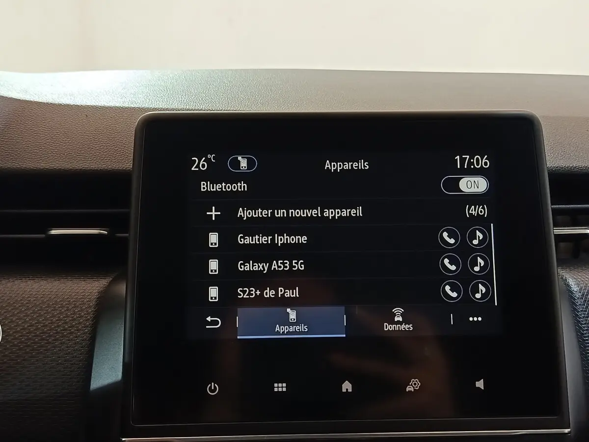 Écran tactile central de la Renault Clio Business E-TECH 140 blanc, affichant la connexion Bluetooth et les appareils appairés.