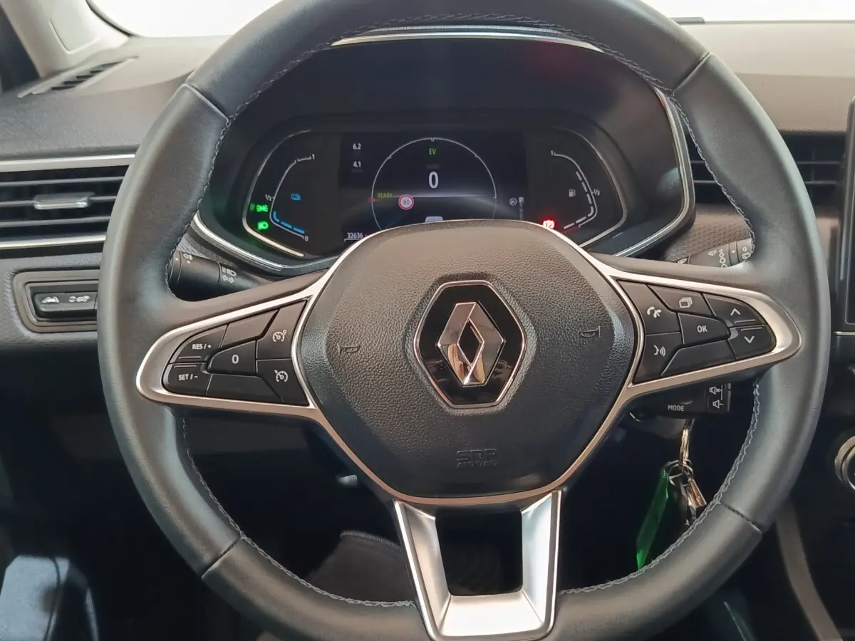 Vue rapprochée du volant noir de la Renault Clio Business E-TECH 140 2021 avec tableau de bord numérique allumé.