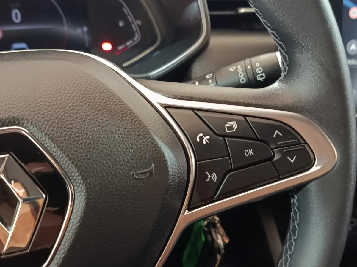 Gros plan sur le volant cuir de la Renault Clio Business E-TECH 140 2021, avec commandes multifonctions visibles.